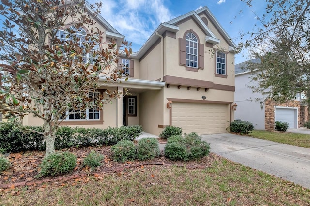 traditional home with a garage, driveway, and stucco siding