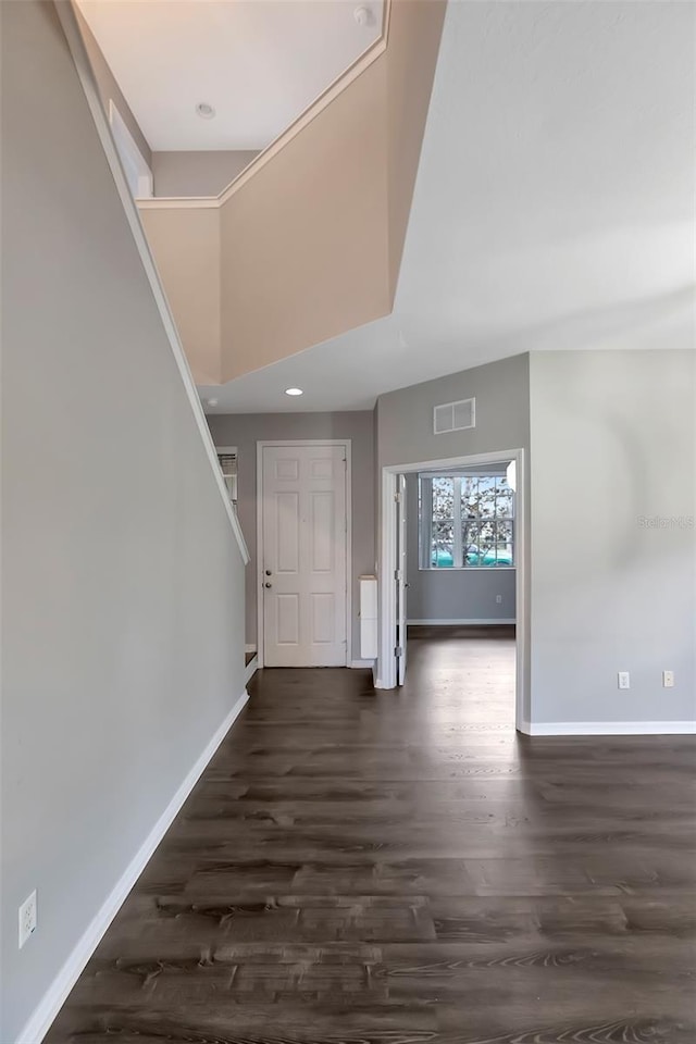 foyer with a high ceiling, dark wood finished floors, visible vents, and baseboards