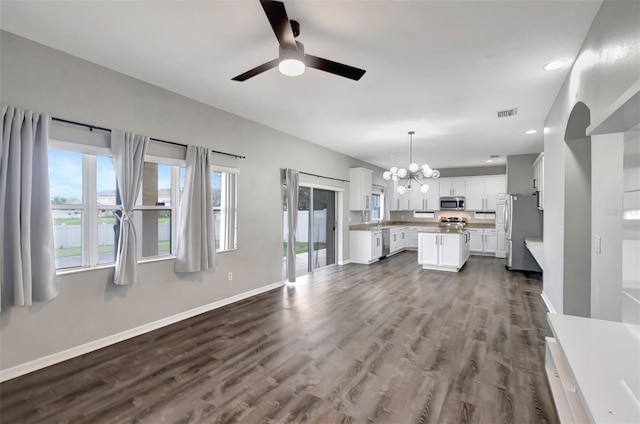 unfurnished living room with dark wood finished floors, recessed lighting, visible vents, baseboards, and ceiling fan with notable chandelier