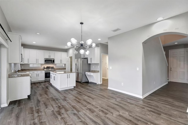 kitchen with dark wood finished floors, visible vents, stainless steel appliances, and a sink