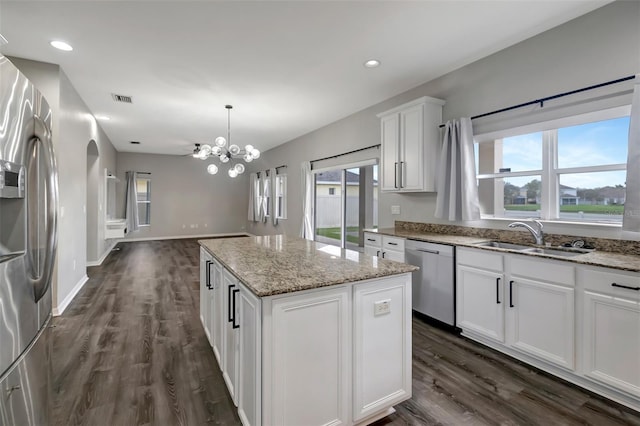 kitchen with a center island, visible vents, appliances with stainless steel finishes, a sink, and plenty of natural light