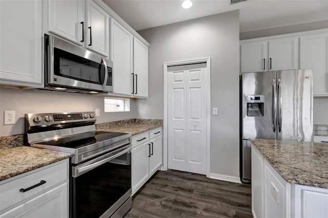 kitchen featuring white cabinets, appliances with stainless steel finishes, dark wood-style flooring, light stone countertops, and recessed lighting