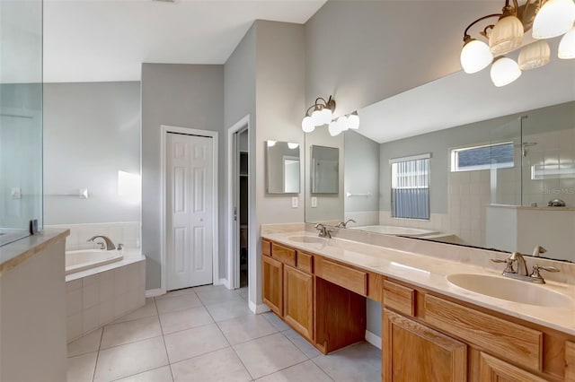 bathroom featuring tile patterned flooring, a garden tub, and a sink