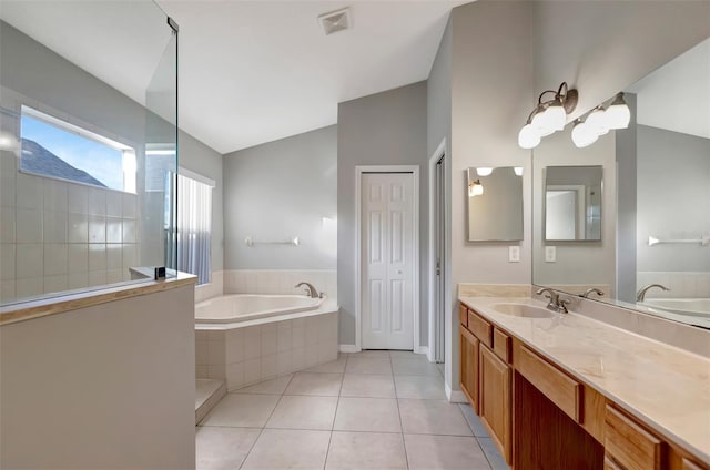 bathroom with lofted ceiling, visible vents, vanity, a bath, and tile patterned floors