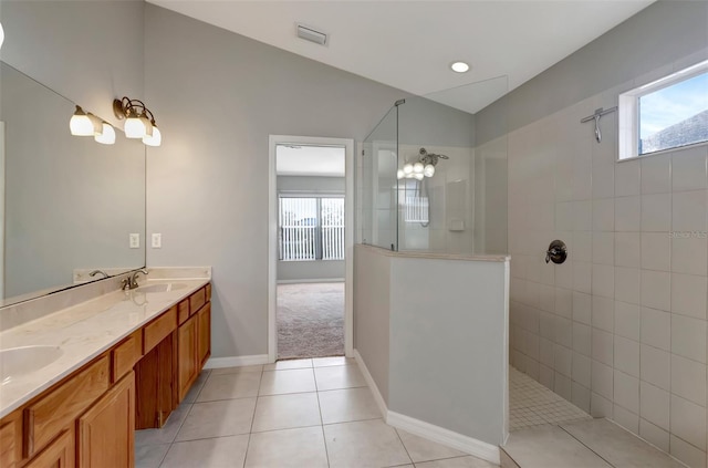 bathroom with visible vents, tile patterned flooring, vaulted ceiling, walk in shower, and a sink