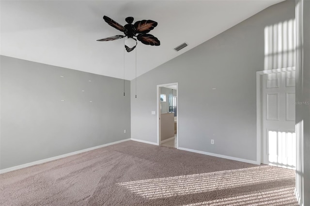 spare room with ceiling fan, high vaulted ceiling, visible vents, baseboards, and carpet