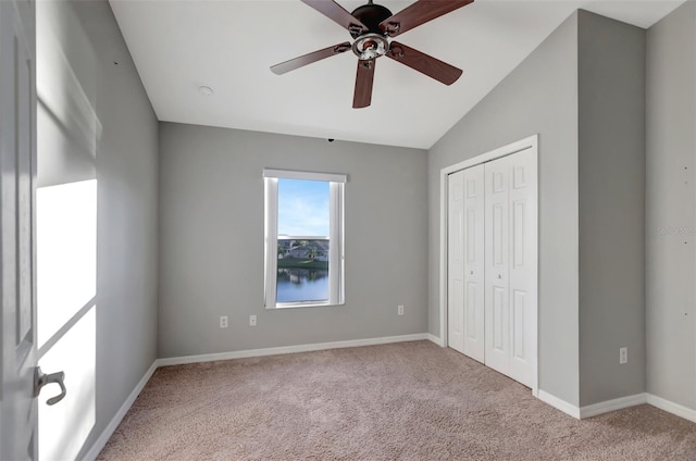 unfurnished bedroom with baseboards, a ceiling fan, lofted ceiling, carpet flooring, and a closet