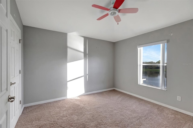 spare room with carpet, ceiling fan, and baseboards