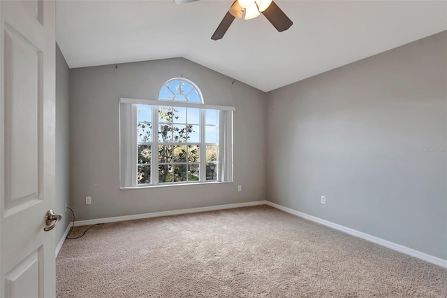 spare room featuring lofted ceiling, carpet floors, ceiling fan, and baseboards