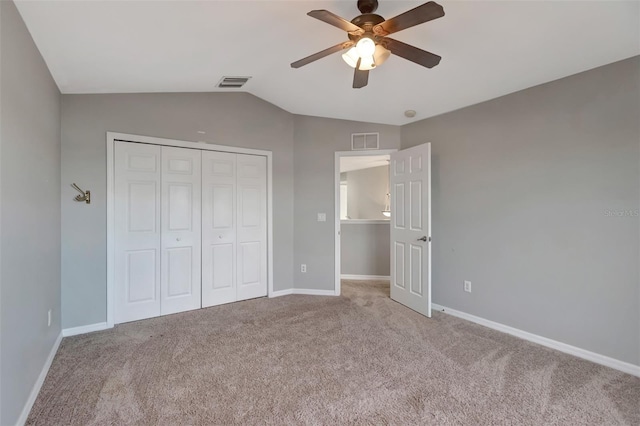 unfurnished bedroom featuring carpet floors, a closet, visible vents, and vaulted ceiling