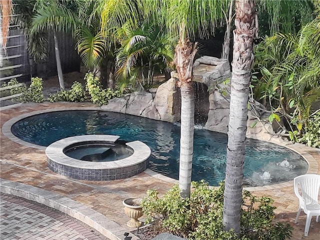 view of swimming pool with a pool with connected hot tub