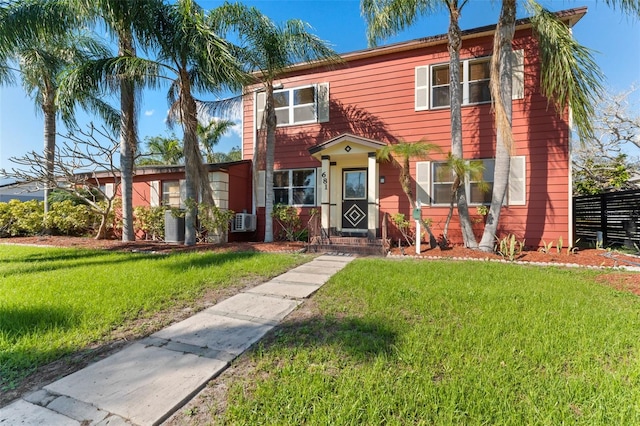 view of front of house featuring cooling unit, a front yard, and fence