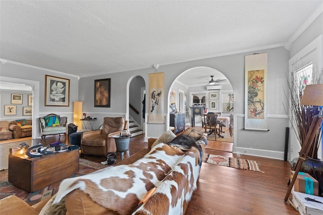 living room featuring arched walkways, a textured ceiling, an AC wall unit, and wood finished floors