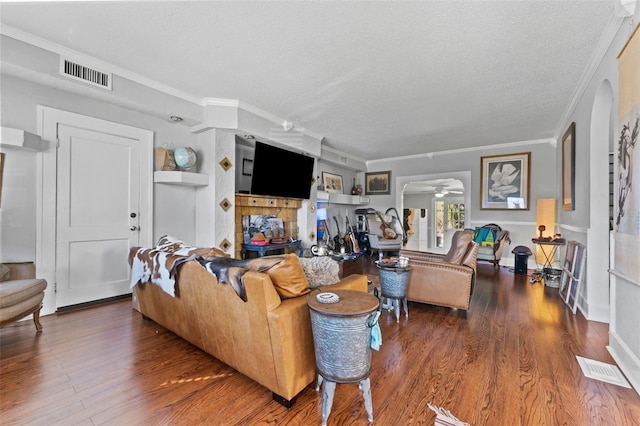 living area with visible vents, a textured ceiling, and wood finished floors