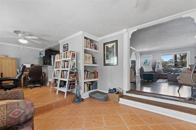 living area with tile patterned floors, arched walkways, a textured ceiling, and ornamental molding