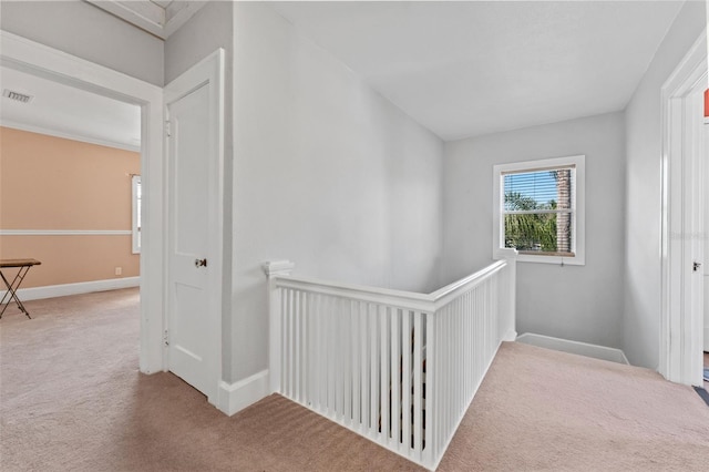 hallway with an upstairs landing, carpet flooring, baseboards, and visible vents