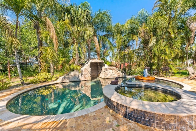 view of swimming pool featuring an in ground hot tub