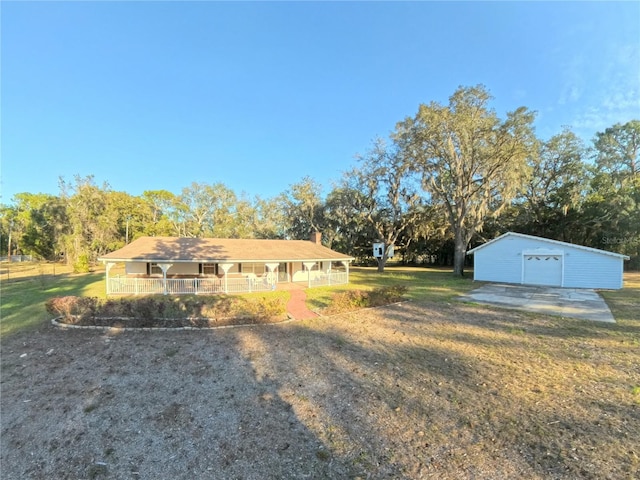 exterior space featuring a garage, a porch, and an outbuilding