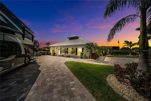 patio terrace at dusk featuring decorative driveway