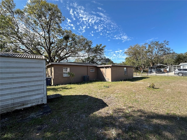 view of yard with central AC unit and an outbuilding