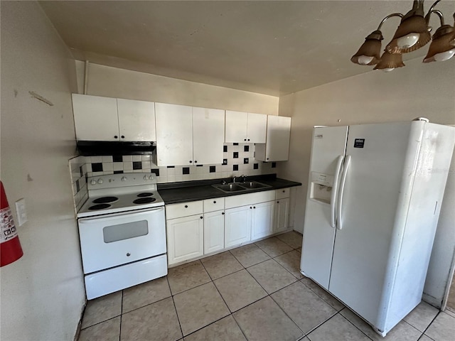 kitchen with white appliances, tasteful backsplash, dark countertops, under cabinet range hood, and a sink