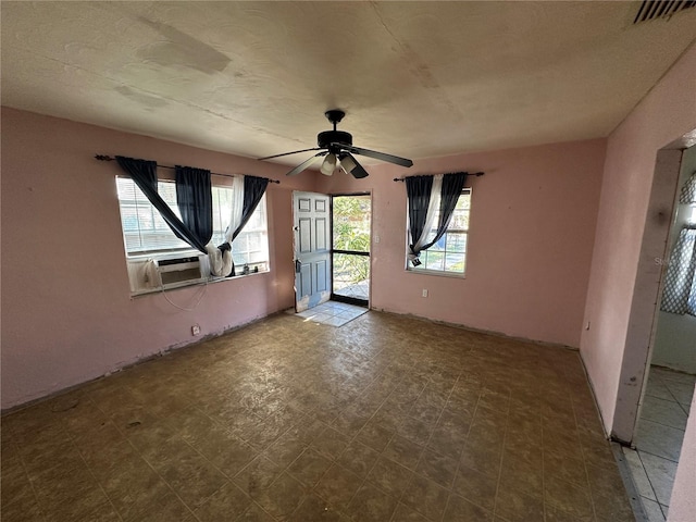 unfurnished room featuring tile patterned floors, cooling unit, visible vents, and a healthy amount of sunlight