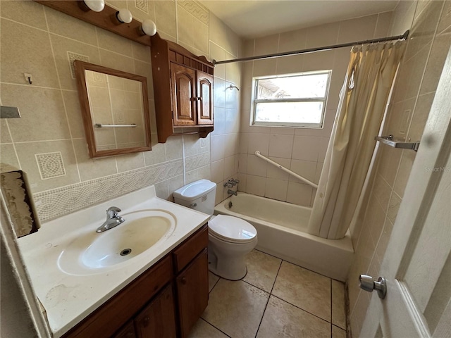 bathroom with shower / tub combo with curtain, tile walls, toilet, vanity, and tile patterned floors