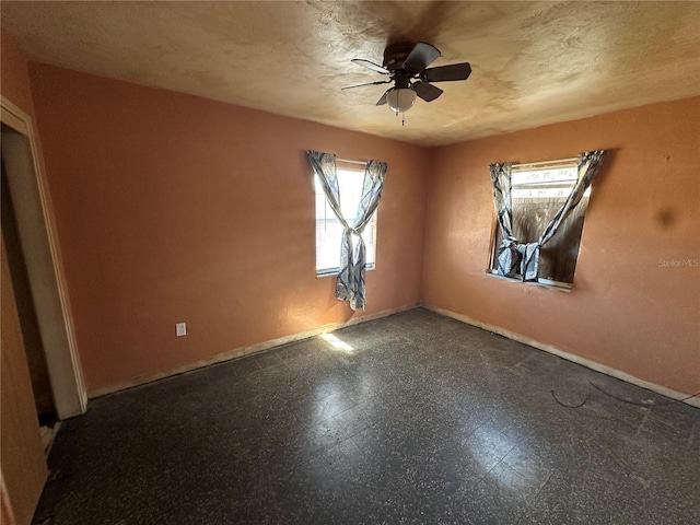 unfurnished room with a textured ceiling, baseboards, a ceiling fan, and tile patterned floors