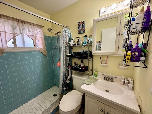 bathroom featuring a tile shower, vanity, and toilet