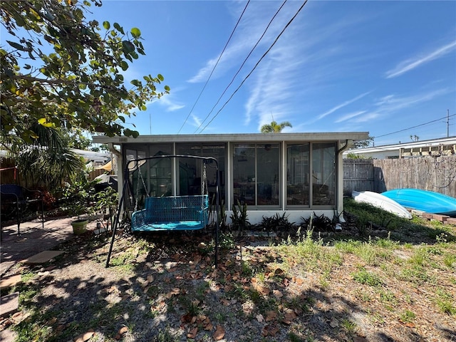 back of house with a sunroom and fence