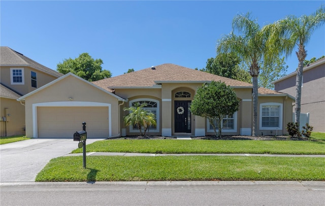 view of front of house with driveway, roof with shingles, an attached garage, a front yard, and stucco siding