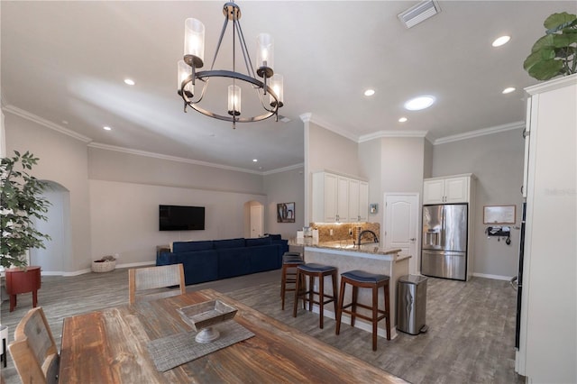 dining area with visible vents, arched walkways, and ornamental molding