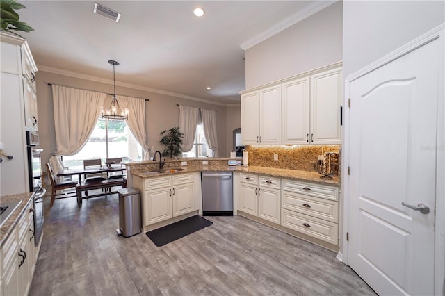 kitchen with a peninsula, light wood-style floors, visible vents, and stainless steel appliances