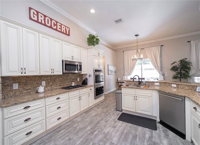 kitchen with tasteful backsplash, visible vents, appliances with stainless steel finishes, ornamental molding, and white cabinetry