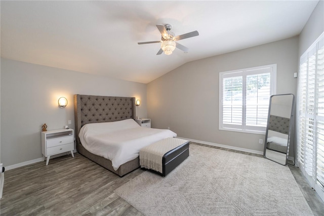 bedroom with lofted ceiling, ceiling fan, baseboards, and wood finished floors