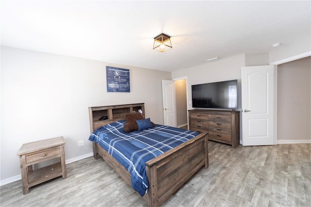 bedroom with baseboards and wood finished floors