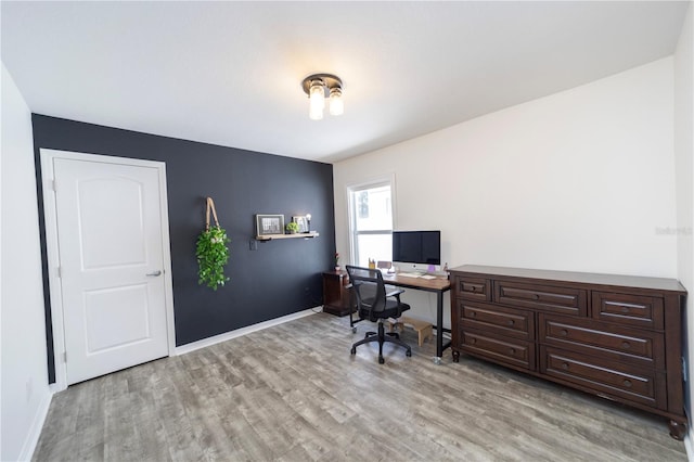 office area with light wood-style floors and baseboards