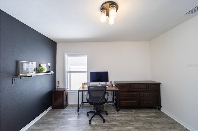 office area featuring baseboards, visible vents, and wood finished floors