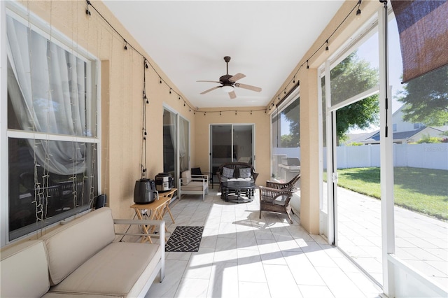 sunroom / solarium featuring a ceiling fan