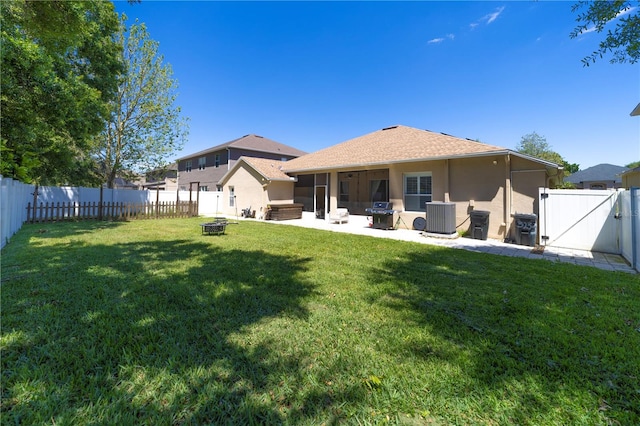 back of property with an outdoor fire pit, central AC unit, a fenced backyard, a lawn, and a gate