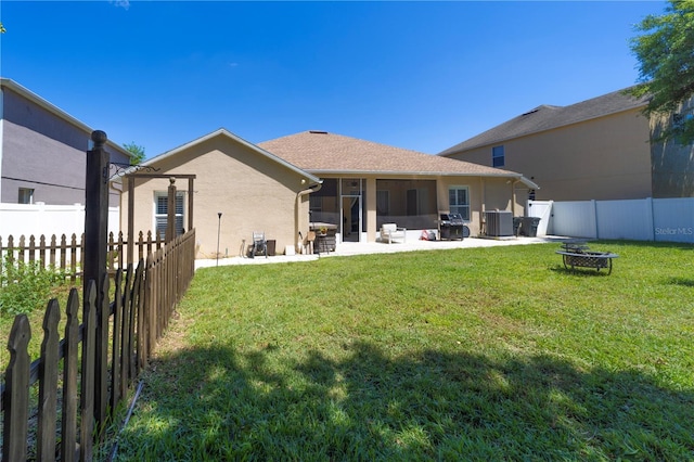 back of house with an outdoor fire pit, a fenced backyard, central AC, a yard, and a patio area