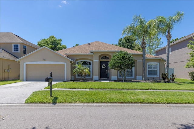 view of front of property with a garage, driveway, a front lawn, and stucco siding