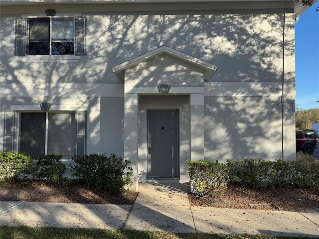 property entrance with stucco siding