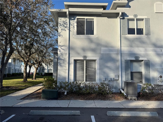 view of front of property featuring central air condition unit and stucco siding