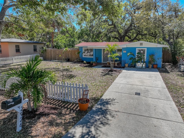 view of front of house with a fenced front yard and stucco siding