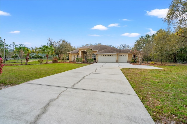 view of front of house with a front yard, driveway, an attached garage, and fence