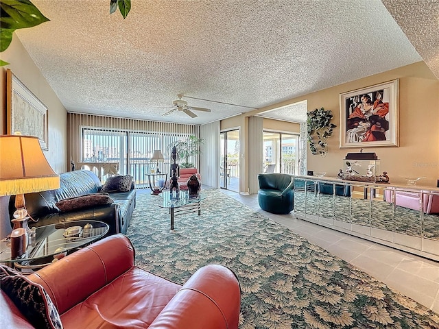 living room with a ceiling fan, tile patterned flooring, and a textured ceiling