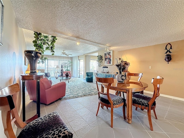 dining space with ceiling fan, a textured ceiling, baseboards, and light tile patterned floors