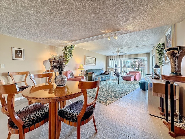 dining space with ceiling fan and a textured ceiling