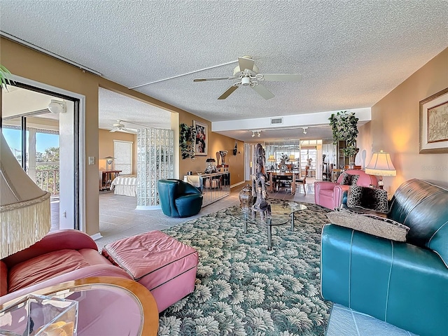 tiled living room featuring a textured ceiling, visible vents, and a ceiling fan